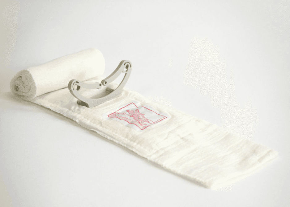 4-inch white Israeli emergency bandage unrolled, showing pressure applicator and sterile dressing for wound compression.