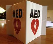 Tented 3D AED Location Sign with bold AED text and heart symbol with lightning bolt. Durable design enhances AED visibility in public areas.